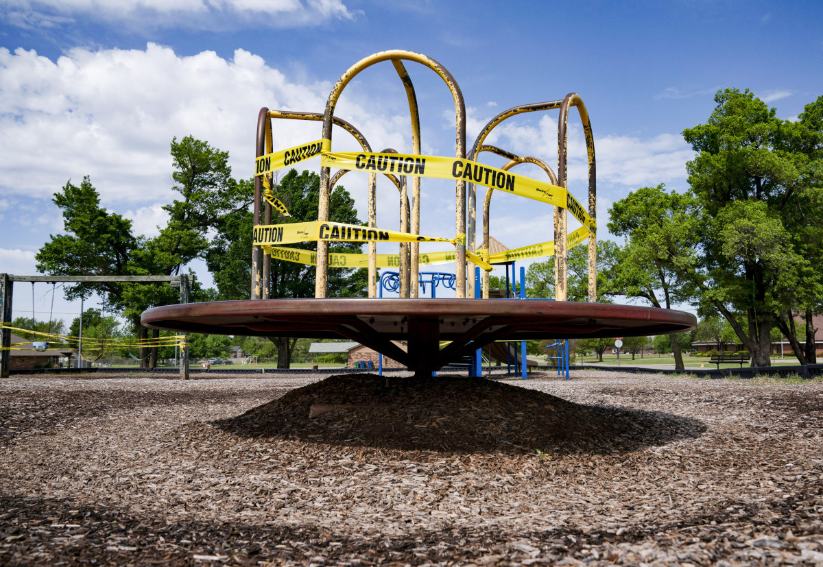 A playground spinner, roped off with caution tape.